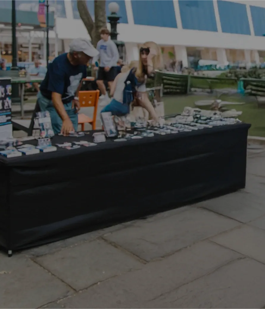 A background photo of volunteers manning a info table in a NYC outreach